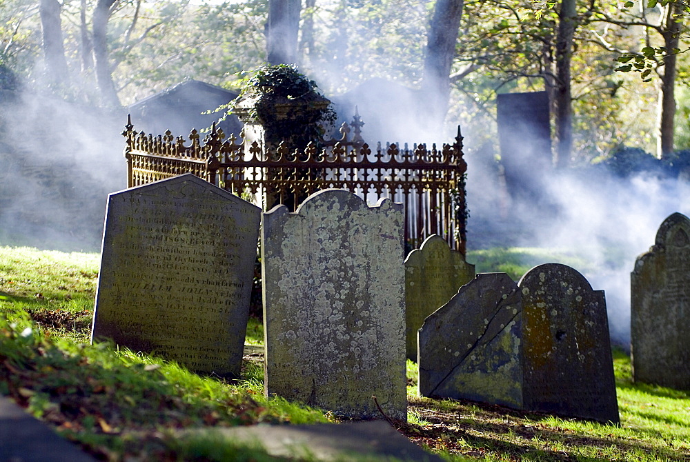 Mist formed over gravestones at a cemetery in St. Davids, Wales, Great Britain, Europe