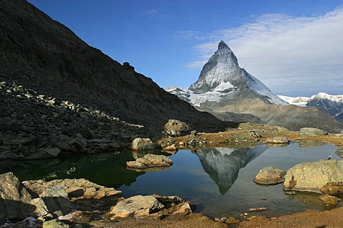 The Matterhorn mountain is reflected in the Riffelsee lake at Gornergrat. Zermatt, Wallis (Switzerland). It is a peak of African crystalline rock, piled up during the continental collision of the African with the European plate that caused the orogeny of 