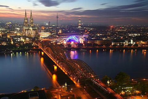 Illuminated city center with Hohenzollern bridge, central train station and cathedral, Cologne, NRW, Germany