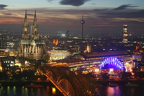 Illuminated city center with Hohenzollern bridge, central train station and cathedral, Cologne, NRW, Germany