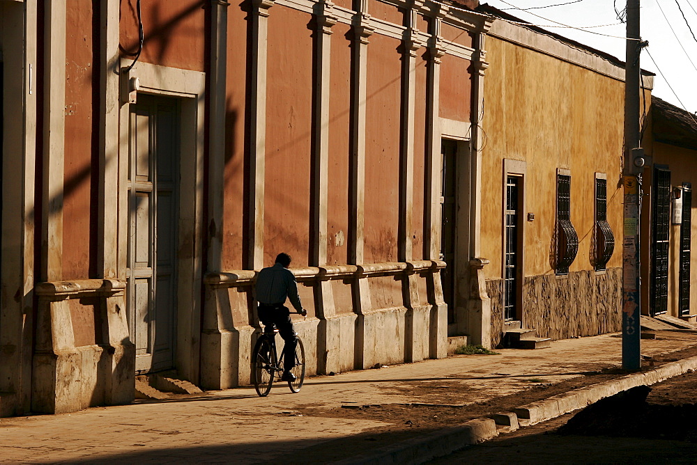 Person riding a bike on an empty pavement, sidewalk in Granada, Nicaragua, Central America