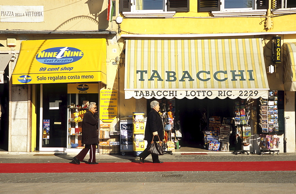 Female pedestrians walking in front of a tobacconist's shop in Salo, Lake Garda, Northern Italy, Italy, Europe