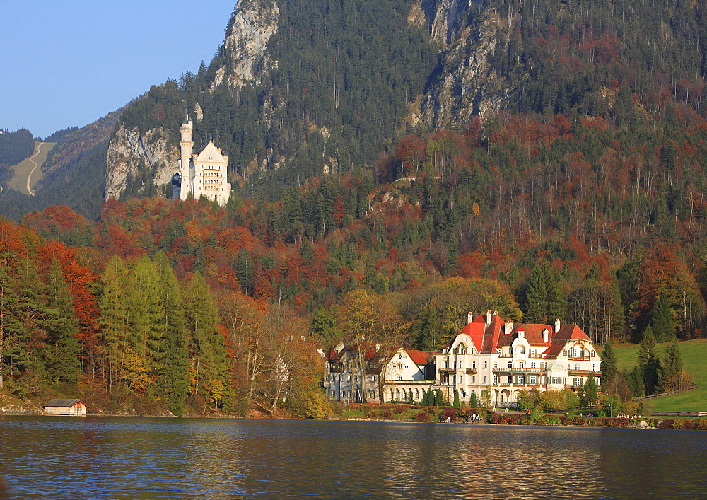 Alpsee lake, Haus Alpenrose and Neuschwanstein Castle in evening light, Schwangau near Fuessen, Bavaria, Germany