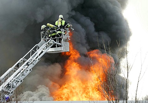 German fire brigade men fights a blaze in a warehouse in Munich Bavaria Germany.