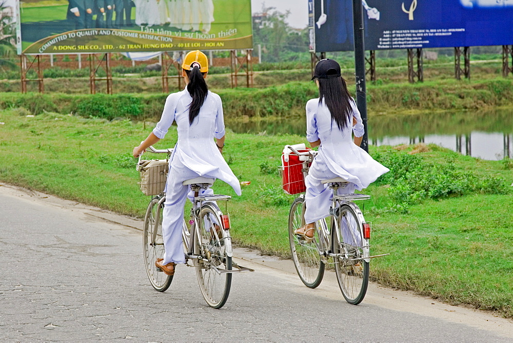 Students in the traditional ao dai dress on the way to school Vietnam