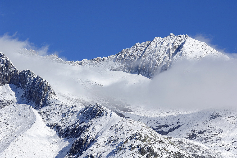 Clouds with snowy mountains in the Aletsch area, Goms, Valais, Switzerland