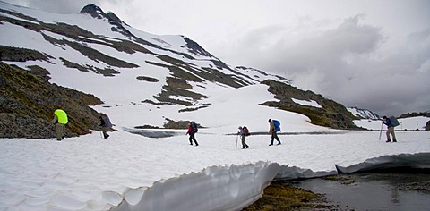 Hikers carrying backpacks crossing a snowy valley along the Chilkoot Trail, British Columbia, Canada, North America