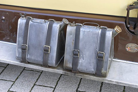 Two jerrycans or canisters on a vintage car