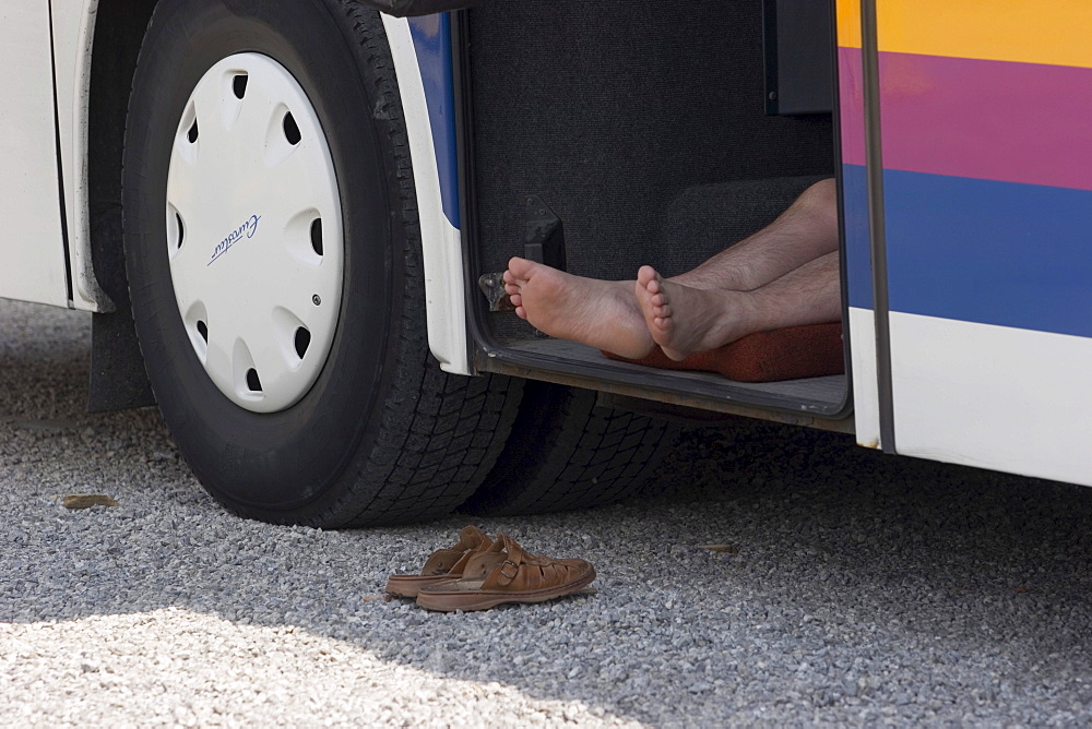 Bus driver sleeping in the cargo hold of his bus, Slovakia