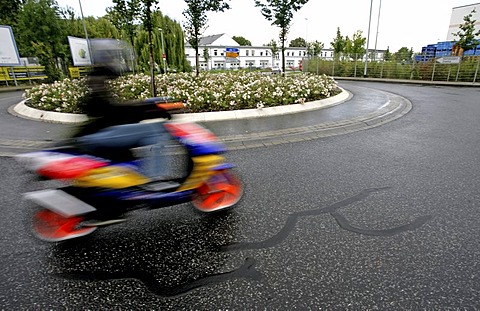 Powered two-wheeler drinving a roundabaut with dangerous paving