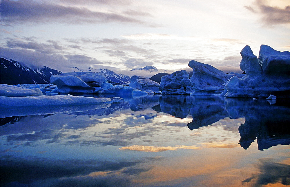 Icebergs reflected on water at sunset, Kenai Fjords National Park, Alaska, USA