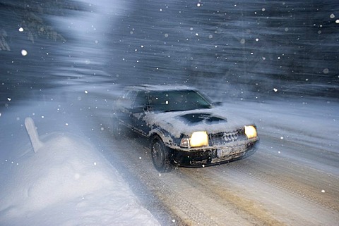 Car at snow flurry road traffic in winter Bavaria Germany