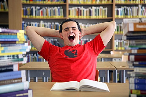 Student yawning and being lazy in a university library