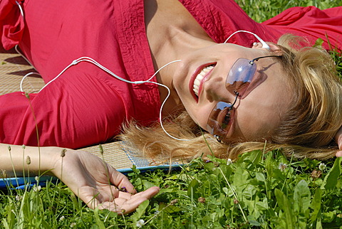 Young woman relaxing with an ipod mp3 player, listening to music