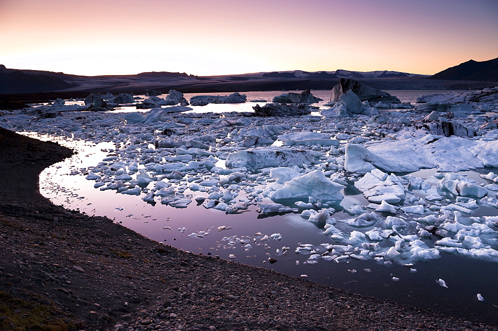 Blue and black icebergs and ice crystals in the evening light, Joekulsarlon glacial lagoon, Vatnajoekull glacier, Austurland, eastern Iceland, Iceland, Europe