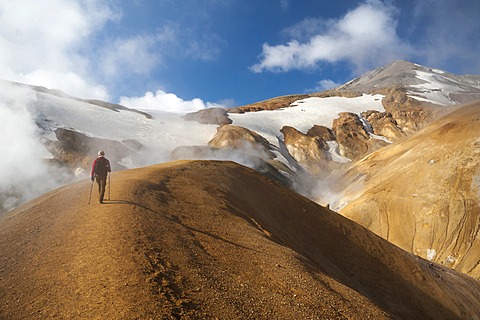 Hiker on a trail, hot springs and snow-capped Rhyolite Mountains, Hveradallir high temperature region, Kerlingarfjoell, highlands, Iceland, Europe