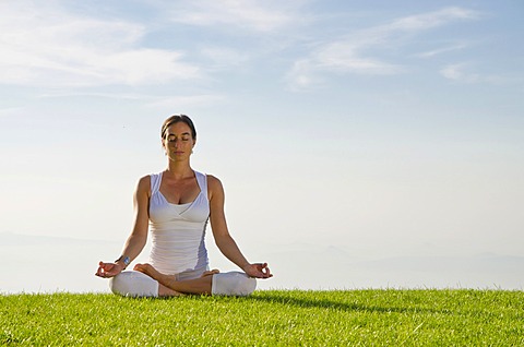 Young woman practising Hatha yoga outdoors, showing the pose padmasana, lotus pose, Nove Mesto, Okres Teplice, Czech Republic, Europe