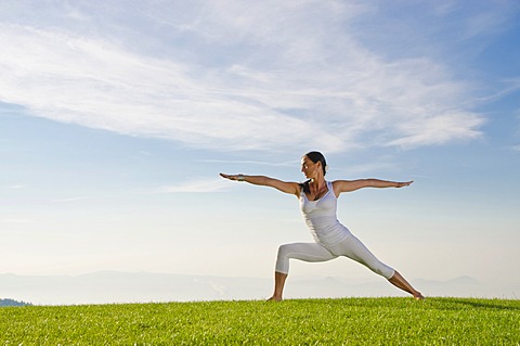 Young woman practising Hatha yoga outdoors, showing the pose virabhadrasana II, proud warrior, Nove Mesto, Okres Teplice, Czech Republic, Europe