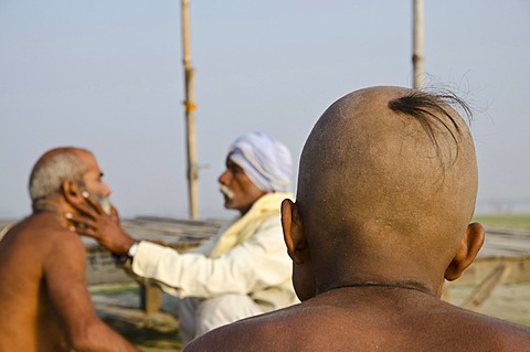 Shaving the head as part of a religious ritual, performed at Sangam, the confluence of the holy rivers Ganges, Yamuna and Saraswati, in Allahabad, Uttar Pradesh, India, Asia