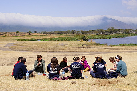 Tourists picnicing in front of the cloud covered edge of the Ngorongoro-crater, Ngorongoro Conservation Area, Tanzania, Africa