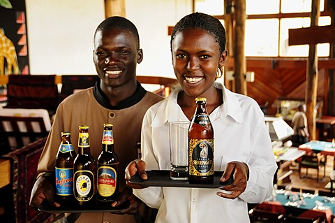 Waiter and waitress carrying the most popular beer brands in Tanzania, Serengeti, Kilimanjaro, Safari and Tusker, Lobo Wildlife Lodge, Serengeti National Park, Tanzania, Africa