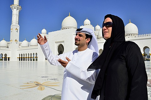 Local man giving veiled tourist a tour of the Sheikh Zayed Mosque, Abu Dhabi, United Arab Emirates, Arabian Peninsula, Asia