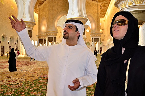 Local man giving veiled tourist a tour of the Sheikh Zayed Mosque, Abu Dhabi, United Arab Emirates, Arabian Peninsula, Asia