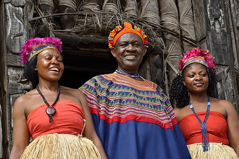 King Fon Abumbi II, head of one of the traditional kingdoms in north west Cameroon, in front of the Achum sanctuary at his seat of power with two of his favourite wives, Bafut Palace, near Bamenda, Cameroon, Central Africa, Africa