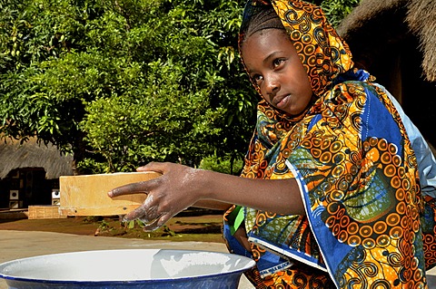 Young girl in the village of Idool sifting flour, near NgaoundâˆšÂ©râˆšÂ©, Cameroon, Central Africa, Africa