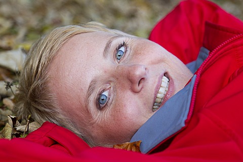 Young woman lying on autumn leaves