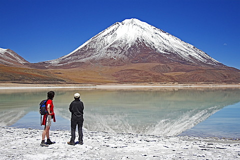 Women standing at the Laguna Verde and Licancabur volcano, Bolivia near the border to Chile, South America