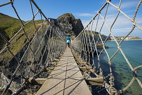 Carrick-a-Rede Bridge, woman crossing the suspension bridge, Moyle, Northern Ireland, United Kingdom, Europe