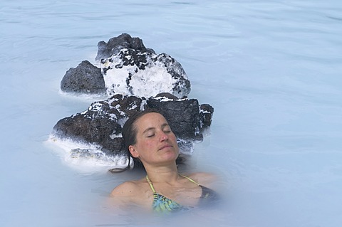 Young woman enjoys bathing in hot spring, Blue Lagoon, Iceland, Europe