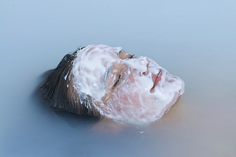 Young woman enjoys bathing in hot spring, Blue Lagoon, Iceland, Europe