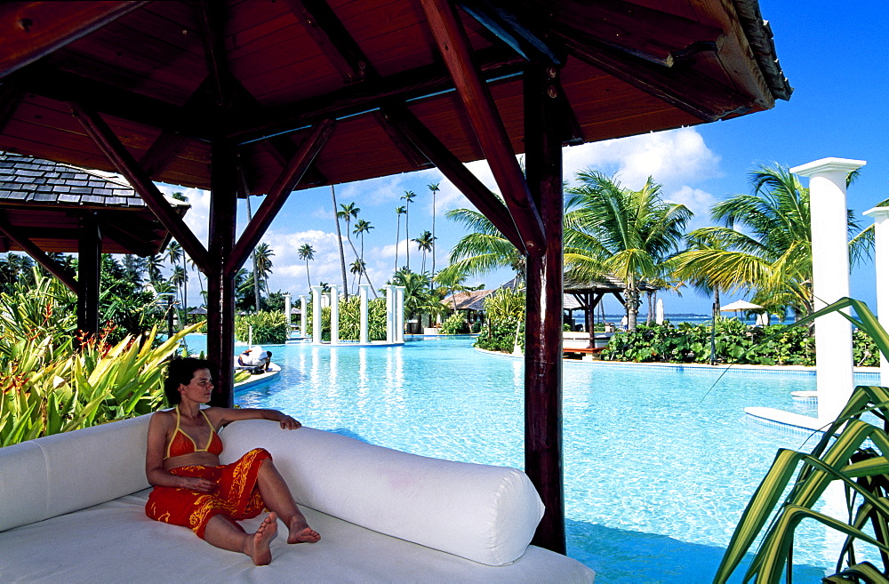 Woman relaxing beside the pool, Gran Melia Resort near Rio Grande, Puerto Rico, Caribbean