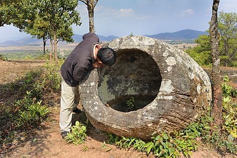 Laotian man at the Plain of Jars, prehistoric stone jars near the town of Phansavan, Laos, Southeast Asia, Asia