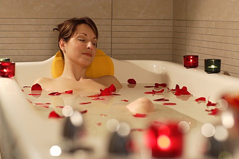 Woman, 35, relaxing in a bathtub with rose petals, Thalasso therapy in a spa resort