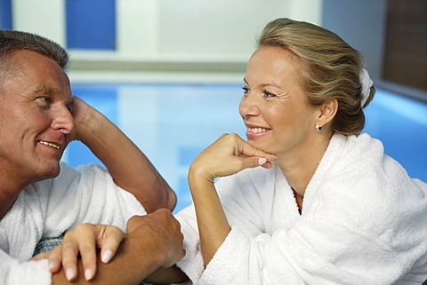 Man, 52 years, and woman, 42 years, talking and smiling, wellness