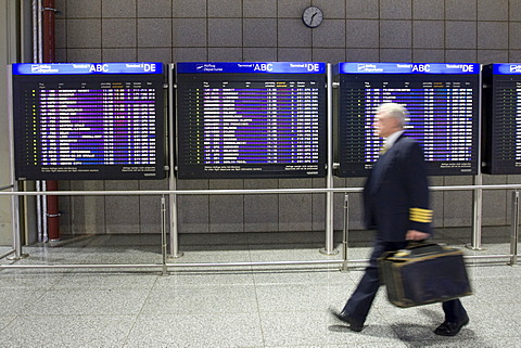 Pilot in front of flight info display screens, Terminal 2, Frankfurt Airport, Frankfurt, Hesse, Germany, Europe