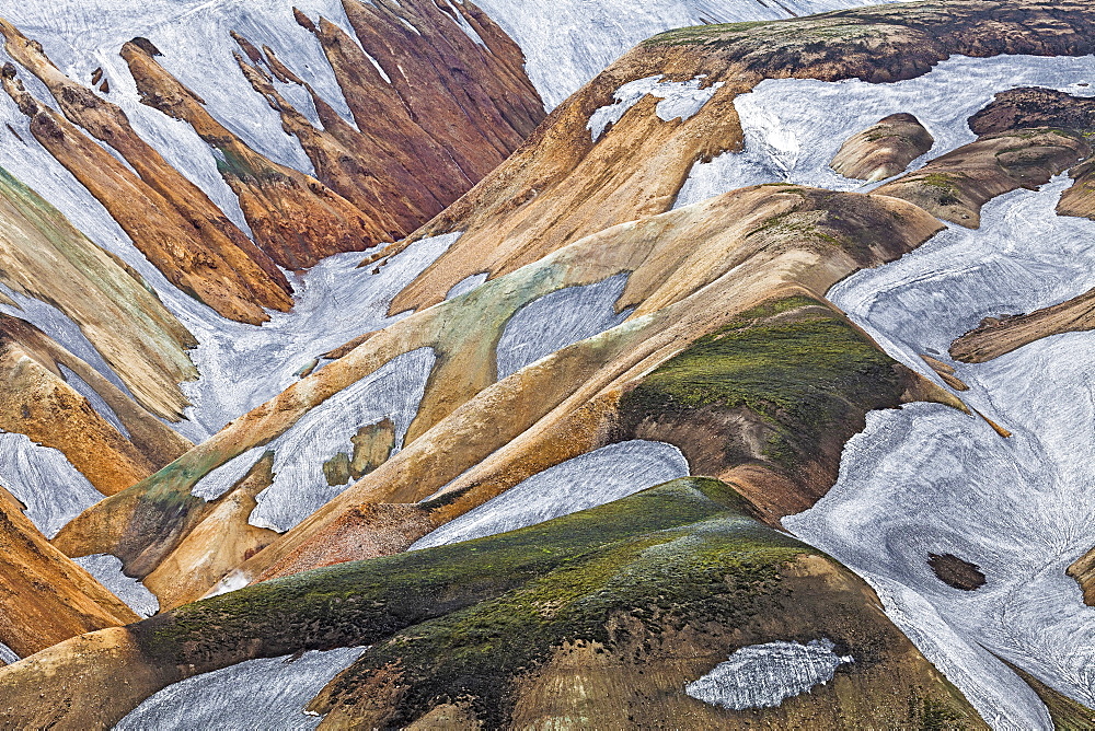 Rhyolite mountains partly covered with moss and snow, in Landmannalaugar, Fjallabak Nature Reserve, Iceland, Europe