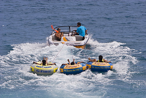 Young people in floating tyres drawn by a motor boat off the beach of the Promenade des Anglais in Nice, CÃ´te d\'Azur, Southern France, France, Europe