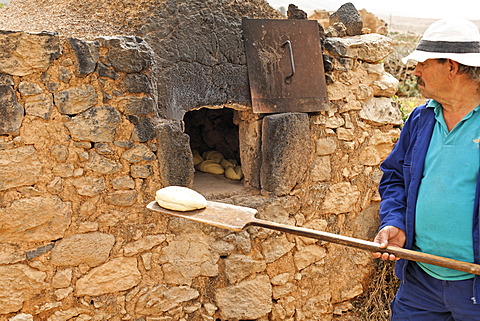 Man baking bread in trditional oven , open-air museum in Tefia , Fuerteventura , Kanarische Inseln