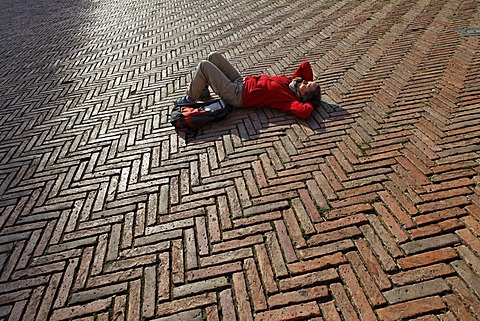 Tourist lying in the Piazza del Campo square, Siena, Tuscany region, province of Siena, Italy, Europe