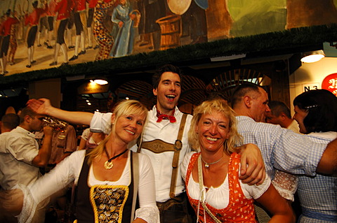 Women wearing traditional dress, called a Dirndl, dancing in the Beer Tent at the Oktoberfest Beer Festival or Wies\'n in Munich, Bavaria, Germany, Europe