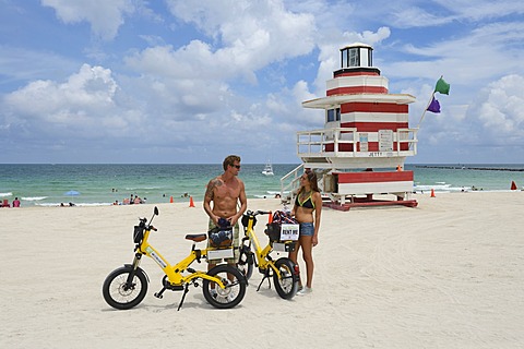 Couple riding electric bicycles, Watchtower, The Jetty, Miami Rescue Tower, South Beach, Miami, Florida, USA