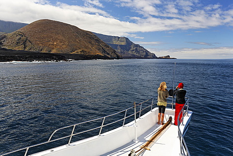 Two woman standing on the bow of the ship, Reina Silvia, volcanic mountains, northern tip of Ponta de Sao Vicente, Isabella Island, Galapagos Archipelago, Ecuador, South America, Pacific Ocean