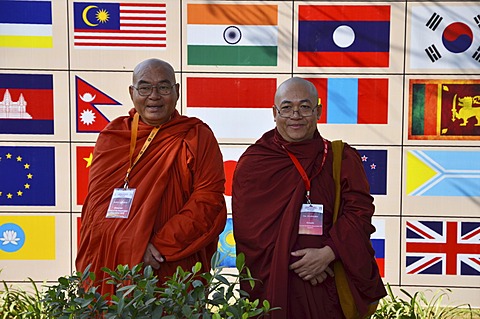 Two monks with red and orange robes, participants of the Global Buddhist Congregation 2011, Buddhist dignitaries from various Buddhist traditions and schools are photographed in front of national flags in Nehru Park, Gandhi Smitri, New Delhi, India, Asia