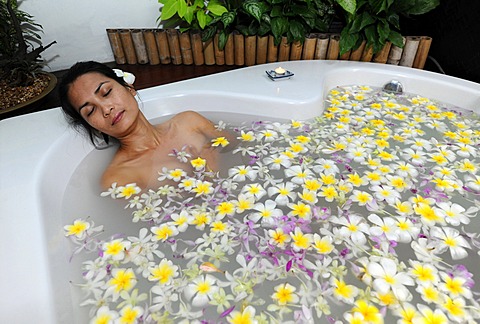 Woman in a sea of flowers in the tub, spa