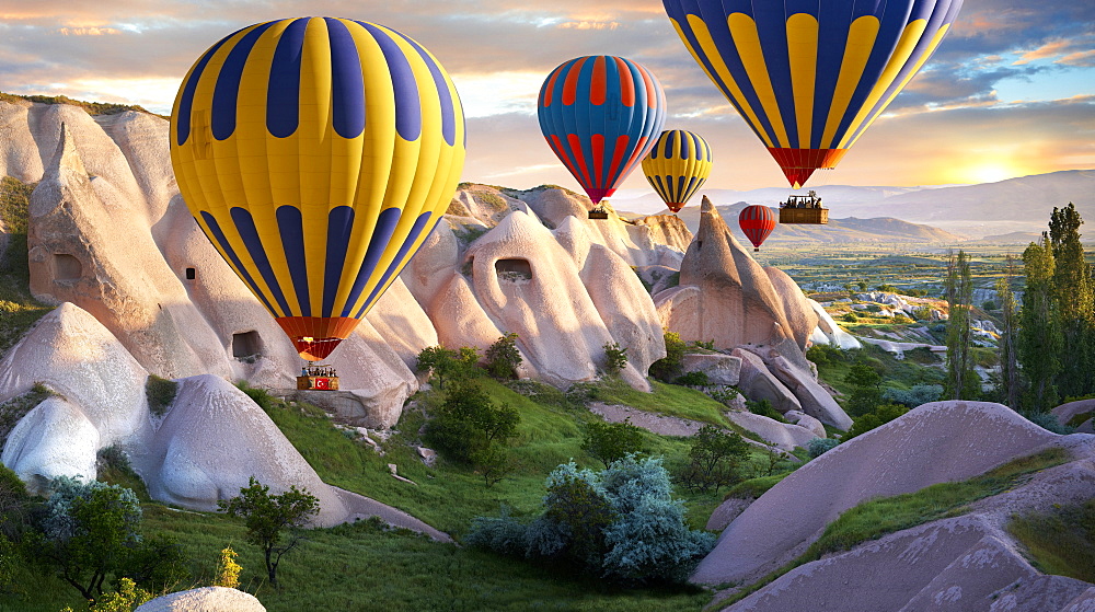 Hot air balloons over Goreme volcanic tuff rock formations at dawn, Cappadocia, Turkey