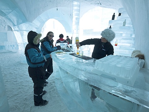 Visitors standing in the Absolut ice bar in the ice hotel in Jukkasjaervi, Kiruna, Lappland, northern Sweden, Sweden, Europe